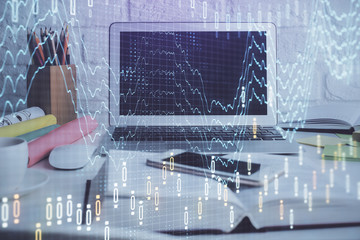 Stock market graph on background with desk and personal computer. Multi exposure. Concept of financial analysis.