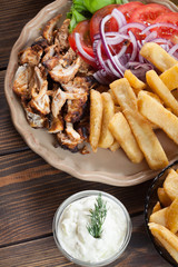 Greek gyros dish with french fries and vegetables