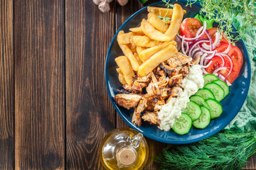 Greek gyros dish with french fries and vegetables
