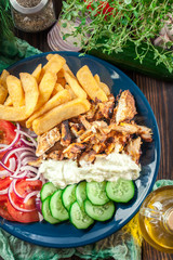 Greek gyros dish with french fries and vegetables