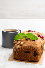 Mixed fruit loaf cake with cup of coffee on wooden table