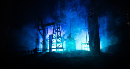 Artwork decoration. Oil pump and oil rig energy industrial machines for petroleum at night with fog and backlight. Oil refining factory. Energy industrial concept. Selective focus