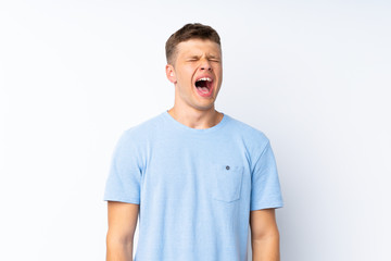 Young handsome man over isolated white background shouting to the front with mouth wide open
