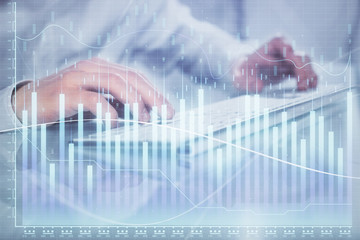 Double exposure of graph with man typing on computer in office on background. Concept of hard work. Closeup.