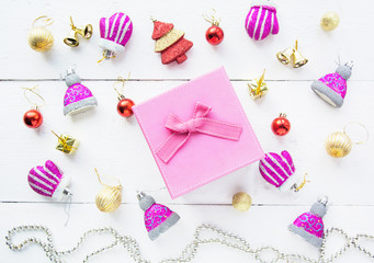 Christmas background top view. Pink and red gift boxes. Coniferous branches and Christmas toys on a background of a white wooden board. New Year 2020