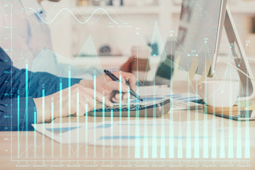 Forex graph with businessman working on computer in office on background. Concept of hardworking. Closeup. Multi exposure.