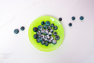 Blueberry and blackberry berries on a green plate