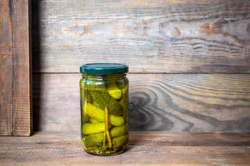 jars of pickled cucumbers on wooden background