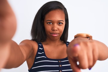 Beautiful young african american woman wearing summer t-shirt over isolated background pointing with finger to the camera and to you, hand sign, positive and confident gesture from the front