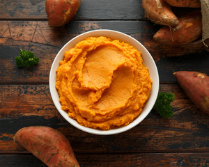 Mashed Sweet Potatoes in white bowl on wooden rustic table. Healthy food