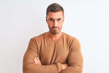 Young handsome elegant man wearing winter sweater over isolated background skeptic and nervous, disapproving expression on face with crossed arms. Negative person.