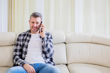 Caucasian man talking on a phone at home