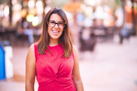 Young beautiful girl smiling happy and confident walking at the town park, standing with a smile on face