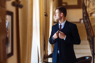 Luxury groom  in suit. Businessman. The morning of the groom, bridegroom's fees. Sexy man  in suit  posing. Happy smiling groom newlywed. 