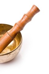 Closeup of a singing bowl and its mallet on a white backround