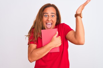 Middle age mature woman reading a book over isolated background very happy and excited, winner expression celebrating victory screaming with big smile and raised hands