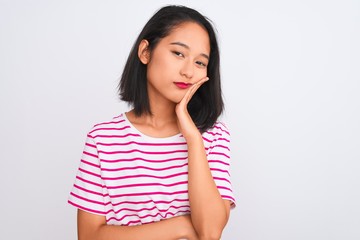 Young chinese woman wearing striped t-shirt standing over isolated white background thinking looking tired and bored with depression problems with crossed arms.