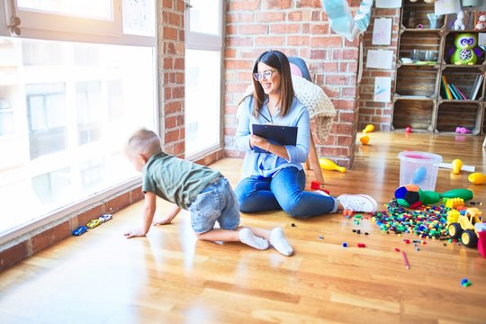 Young therapist woman speaking with child, counselor and behaviour correction at the office around toys