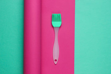 Kitchen brush on wrapped paper background. Minimalistic cooking still life. Pastel color trend