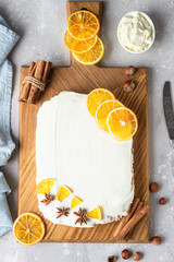 Raw carrot cake with cream cheese frosting, dried orange slices and spices (cinnamon and anise). Healthy food. 