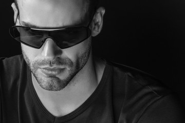 Black and White Muscle strong beautiful stripped male model with white black t-shirt and glasses eyewear on black isolated font background