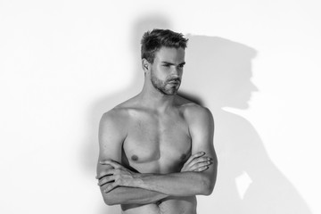 Fototapeta premium Black and White Muscle strong beautiful stripped male model in denim jeans on white isolated font background with shadows