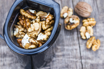 Walnut kernels in a coffee grinder on an old wooden table.