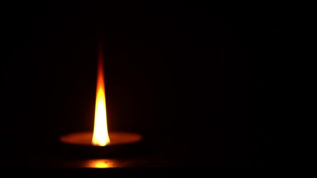 Lighting a camphor against a dar background .