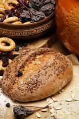 fresh bread, bagels, dried fruits, seeds, salt, jar and wheat on the wooden - still life and healthy eating concept
