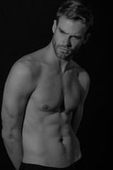 Fototapeta premium Black and White Strong stripped muscle male model in black underwear on black isolated font background