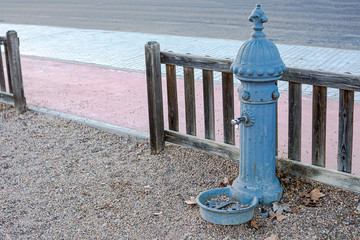 Worn classic fountain for children to drink and cool off in a children's playground in the autumn...