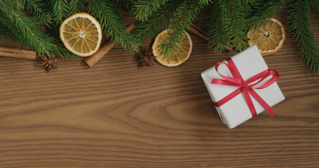 Top view christmas composition with white gift box, spruce branches and natural decorations