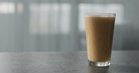 nitro light ale beer pouring into pint glass on terrazzo countertop with window on background
