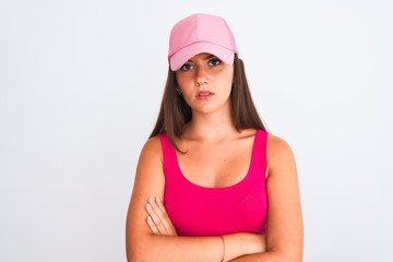 Obraz na płótnie Canvas Young beautiful girl wearing pink casual t-shirt and cap over isolated white background skeptic and nervous, disapproving expression on face with crossed arms. Negative person.