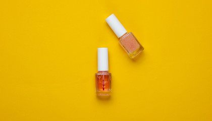 Nail polish bottles on a yellow background. Beauty and fashion concept