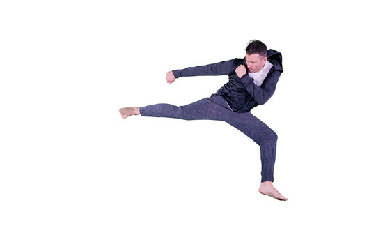 Young man performing karate kick on studio