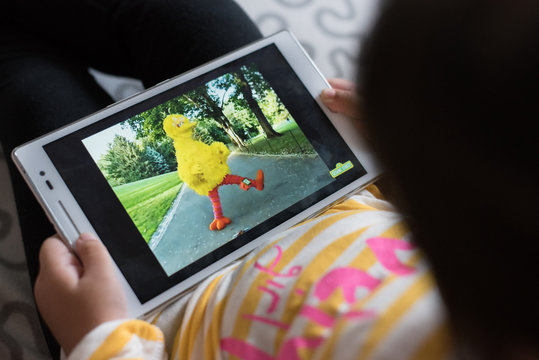 Petaling Jaya, Selangor, Malaysia - 03 November 2019 - Little girl wathing Sesame Street on a digital tablet. Sesame Street is a longtime favorite of children and adults