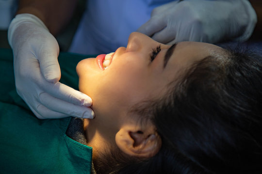 Dentist examining mouth teeth of beautiful young Asian woman in hospital clinic dental health care beautify oral hygiene concept