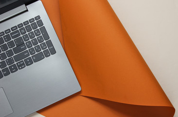 Laptop on a colored paper background. Studio shot, top view