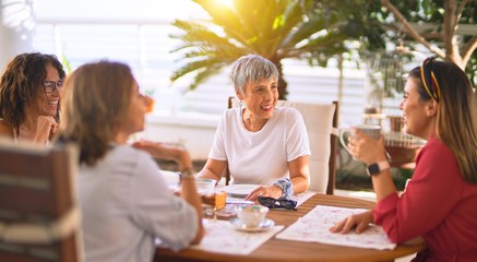 Young beautiful girl smiling happy and confident sitting dinking cup of coffee at terrace