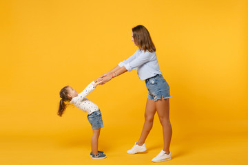 Fototapeta na wymiar Woman in light clothes have fun with cute child baby girl 4-5 years old. Mommy little kid daughter isolated on yellow background studio portrait. Mother's Day love family parenthood childhood concept.