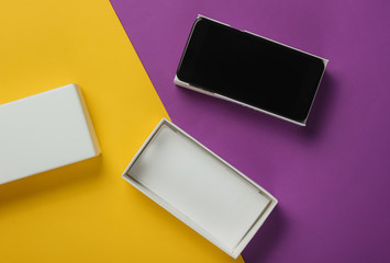 New modern smartphone in box on colored background. Minimalistic fashion concept, gift