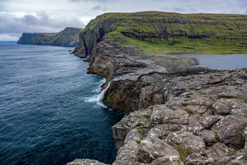 Bosdalafossur waterfall to the ocean on Vagar island coastline