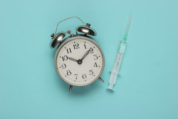 Time to get an injection. Medical still life on a blue studio background. Top view. Flat