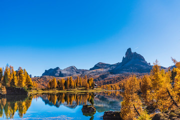 Golden reflections on the Federa lake. Dreamlike Dolomites. Italy