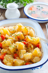 Baked sliced potatoes with carrots and onions, selective focus