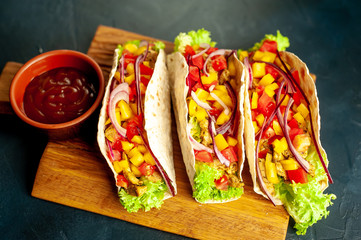 Mexican tacos with meat and vegetables on a stone background with copy space for your text.