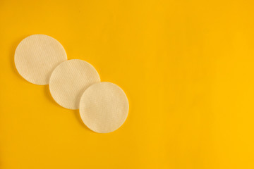 Cosmetology or skincare concept. Three white sponges to clean skin or makeup removing. Yellow blank background with group line