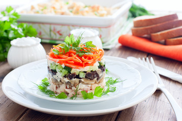 Salad with mushrooms, prunes, Korean carrots on a white plate, selective focus
