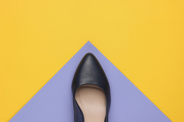 Fototapeta premium Classic women's high heel shoe on color paper background. Stylish shoes. Minimalistic fashion still life.